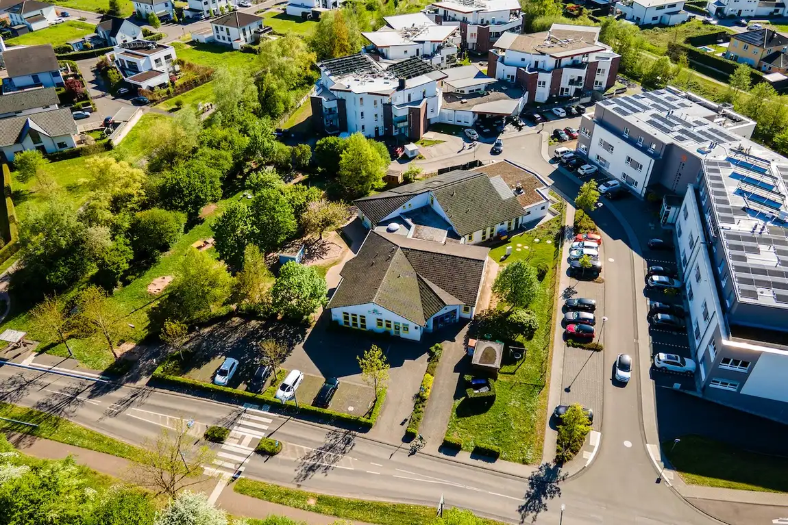 Luftaufnahme des Kita-Geländes der Kita Schweich mit Straße und Parkplatz