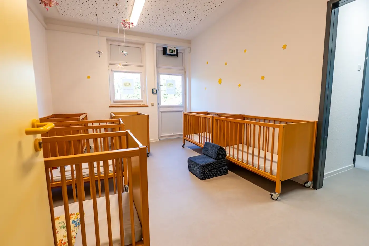 Schlafraum der Krippe mit Kinderbetten und Sternendekoration in der Kita Schweich