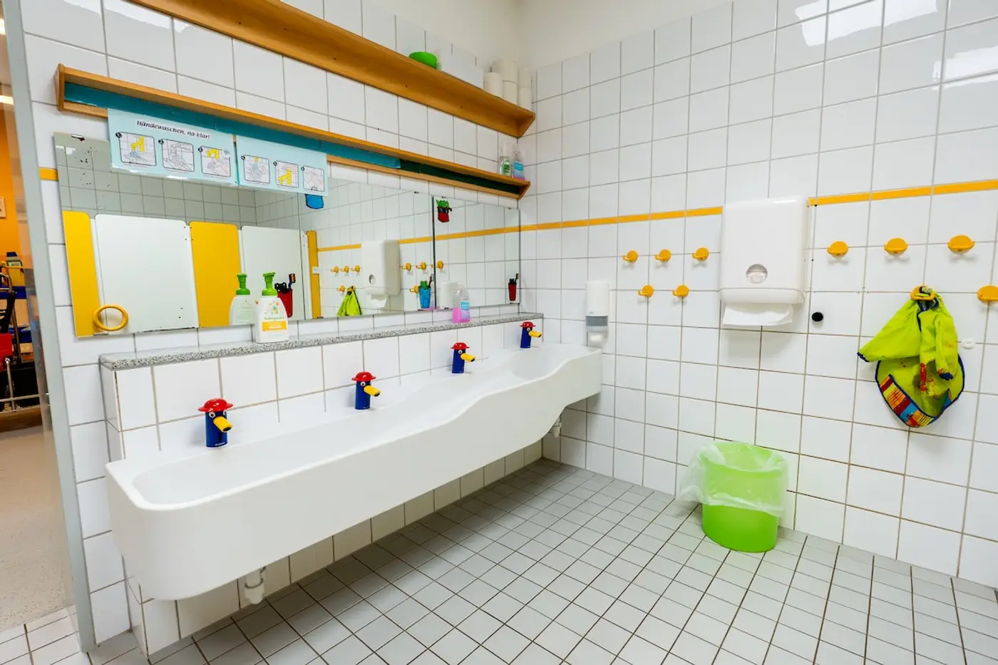 Waschraum der Kita Schweich mit langem Kinderwaschbecken und Armaturen in Pinguinform